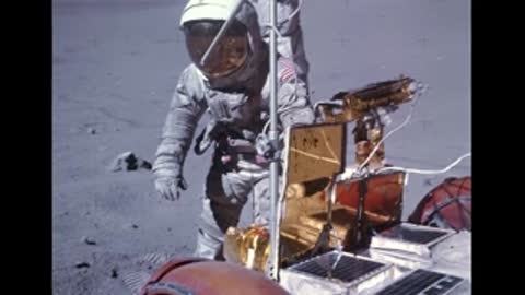 Astronaut working near equipment on the moon.