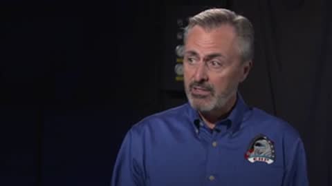 Man speaking in studio setting.