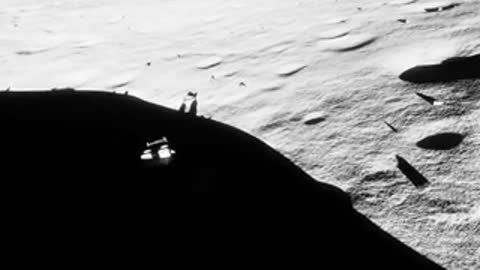 Lunar rover driving along a crater edge with shadows.