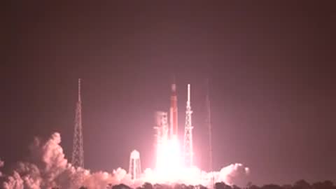 Large rocket launching at night with bright illumination on pad.