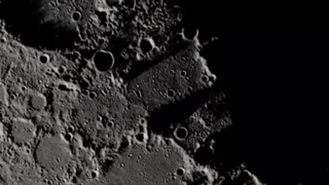 Detailed lunar surface topography showing craters and ridges in shadow.