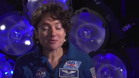 Split view of speaker talking and archival footage of astronaut walking.