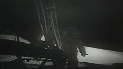 Archival footage of astronaut descending the ladder onto the lunar surface