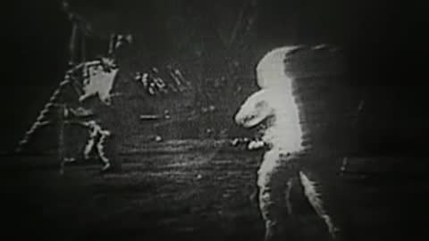 Archival footage of two astronauts walking on the lunar surface