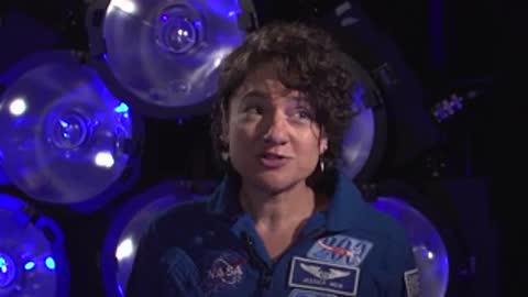 A woman speaking in front of stage lights during an interview