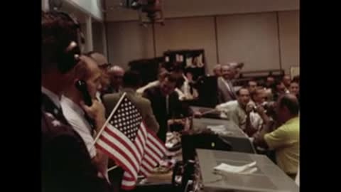 Mission control cheering and waving American flags during Apollo mission