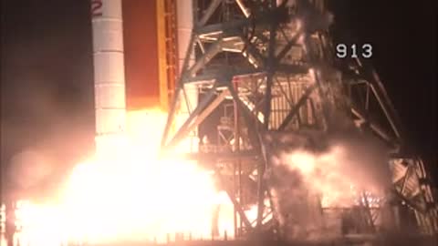A massive space rocket lifts off from the launch pad amidst fire and smoke.