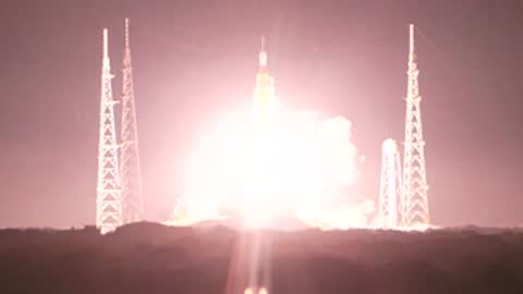 A huge space rocket ascends from the launch pad in a massive explosion of light.