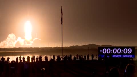Crowds watch a bright space rocket launch into the night sky with timestamps.