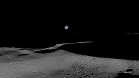 A view of the dark lunar surface with a distant planet visible in the black sky.