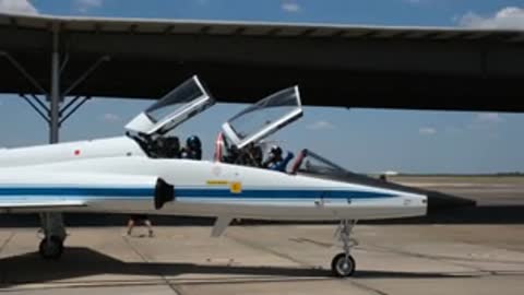 White training jets sit on the tarmac with canopies open.