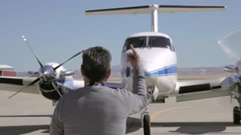 A ground crew member signaling to the airplane before taxiing.