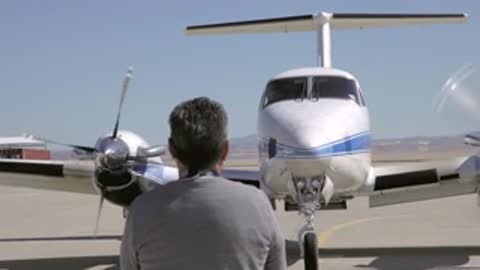 A crew member signaling with hand gestures to the airplane.