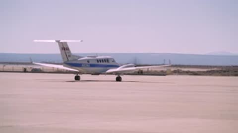 The NASA airplane turning around on the runway.