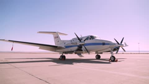 Static view of the NASA B200 King Air airplane parked on tarmac.