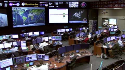 Flight Control Room showing large screens with maps and data displays.