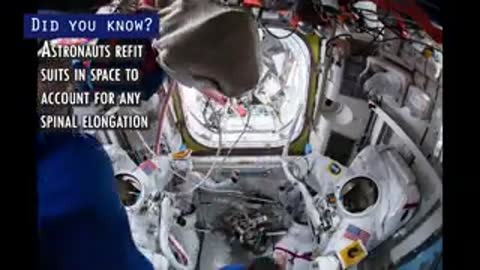 Astronauts inside the International Space Station adjusting and checking white spacesuits.