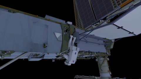 Astronaut tethered to station truss during spacewalk.