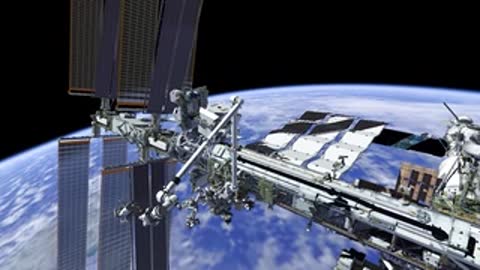 Wide shot of robotic arm positioned on space station truss.
