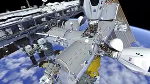 View of astronaut and robotic arm on ISS