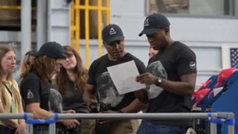 Instructor reviewing flight documents with an astronaut wearing a black shirt.