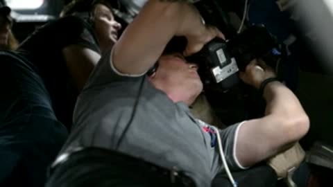Astronaut looking through camera viewfinder in vehicle simulator.