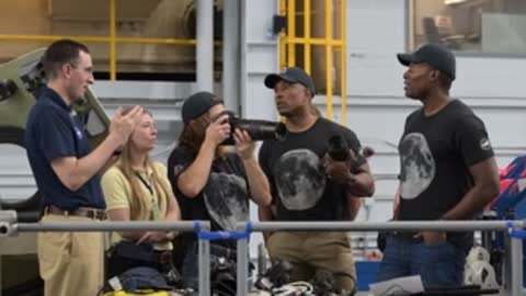 Instructors showing camera equipment to astronauts during a training session.