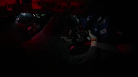 Interior of vehicle simulator illuminated by red lighting.