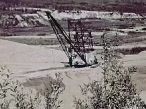 A large industrial crane operating in a mining or excavation area.