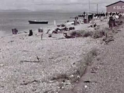 Gravel beach of a coastal village with boats and wooden structures