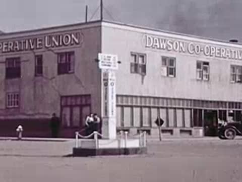 A corner view of the Dawson Co-operative Union building with a gas pump out front.