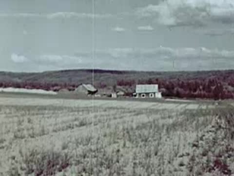 Panoramic view of a farm settlement with low houses and flat fields