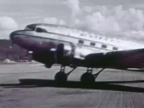Silver twin-engine passenger airliner parked on the tarmac at an airport