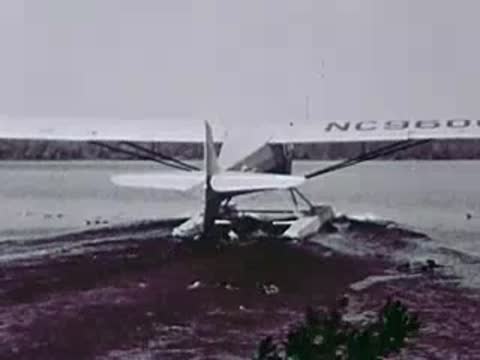 Floatplane taxiing onto the muddy shoreline of a lake