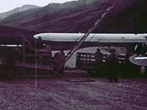 Large industrial pipe being loaded onto a truck with construction equipment