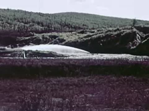 High-pressure water cannon spraying a hillside in a mining operation