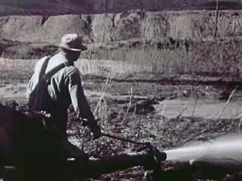 Miner operating a high-pressure water hose in a mining operation