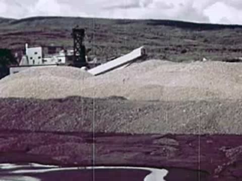 Large pile of gravel or ore with an industrial conveyor system