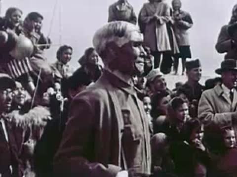 An elderly man in a crowd of onlookers, community gathering, 1940s