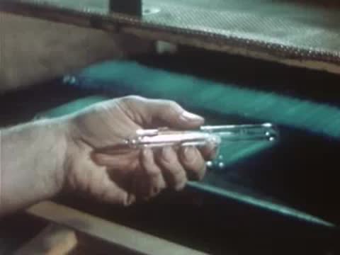 Worker placing finished glass capsules onto a production tray.
