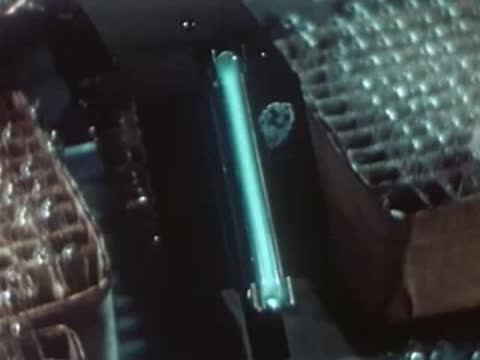 Worker removing protective glass tube from ultraviolet lamp setup in laboratory.
