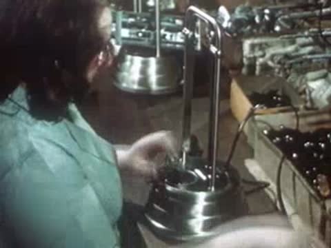 Workers assembling finished electrical appliances on factory production line.