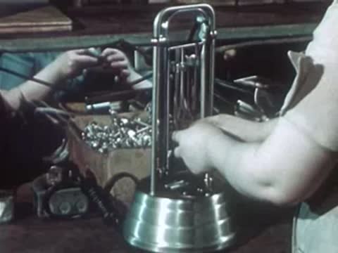 Workers assembling ultraviolet lamp units on factory production line.
