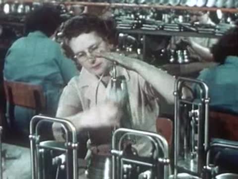 Workers assembling and inspecting portable ultraviolet lamp units in factory.
