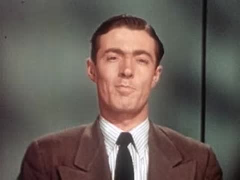 Close-up of dapper man in suit and tie smiling towards camera.