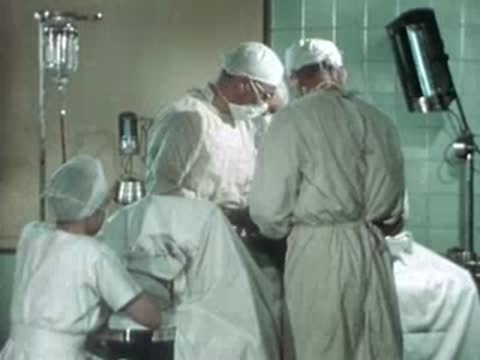 Medical team performing surgery in a brightly lit operating room.