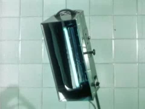 Medical UV lamp fixture mounted on a tiled wall, vintage equipment.