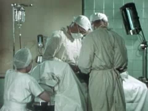 Medical team working around a patient on an operating table.