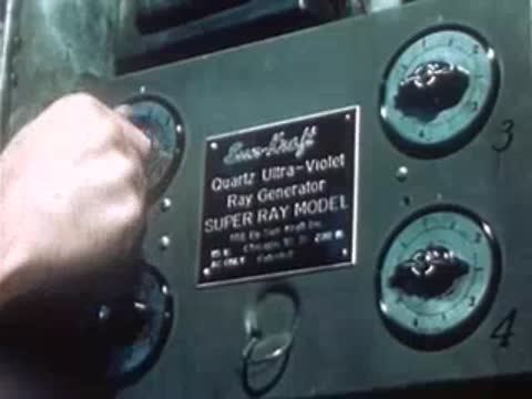 Hand adjusting a dial on a vintage electrical medical control panel.
