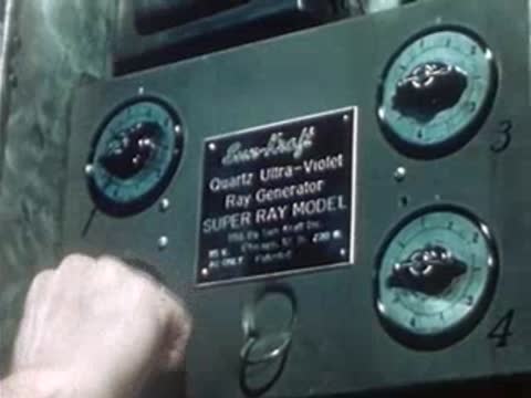Hand turning a dial on a Sun-Kraft medical ray generator panel.